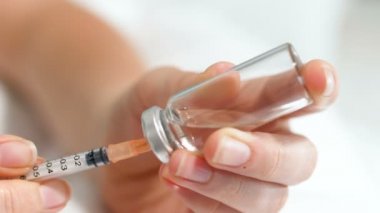 Closeup iğne plastik kap ve dolum şırıngada ekleme ilaçlarla birlikte ampul tutan kadın 4k video