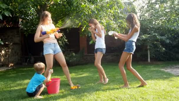 4 k video van jonge moeder met water guns gevecht met haar kinderen op achtertuin — Stockvideo