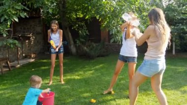 mutlu aile arka bahçe çim üzerinde su savaş sahip gülen 4 k video.