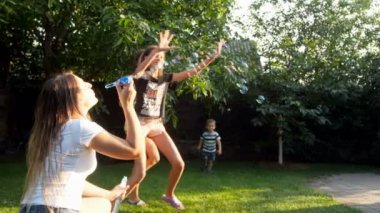 sabun köpüğü günbatımında uçan sonra çalışan mutlu neşeli aile 4 k görüntüleri