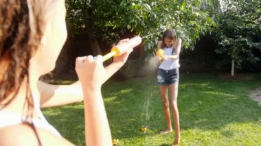 Ağır çekim video, plastik oyuncak tabanca birbirimize su sıçramasına iki genç kız