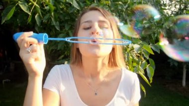 Güzel genç kadın kamera sabun köpüğü üfleme closeup yavaş mtoion görüntüleri