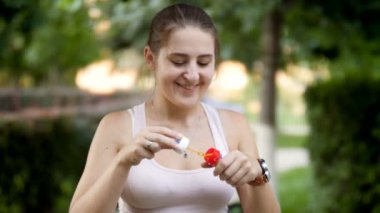 4 k görüntüleri güzel gülümseyen genç kadının sabun köpüğü parkta günbatımında yapma.