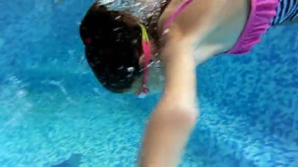 4k underwater video of teeange girl in swimming goggles and striped swimsuit diving in pool — Stock Video