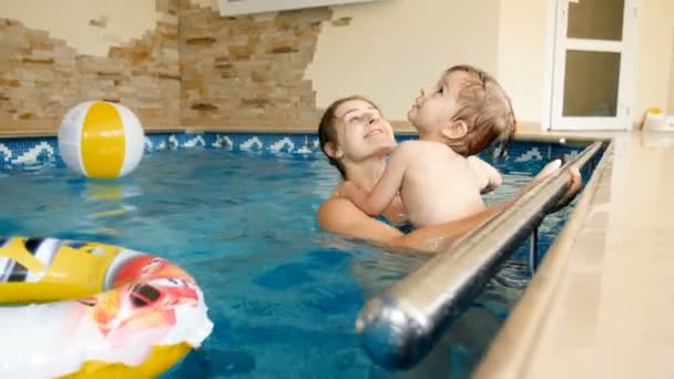 4 k video havuzu annesi ile yüzme ve şişirilebilir oyuncakları ile oynarken yürümeye başlayan çocuk — Stok video