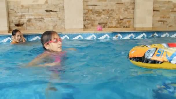 4k кадры счастливой молодой семьи с детьми, купающимися в закрытом бассейне дома — стоковое видео
