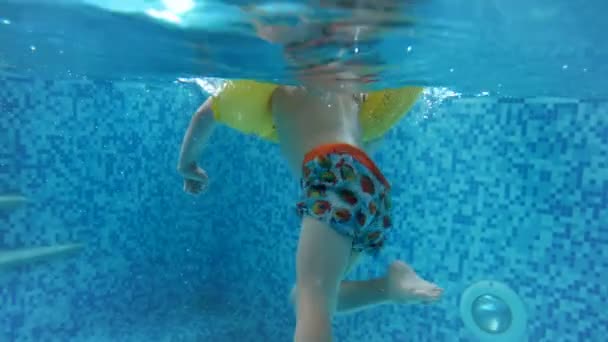 Onderwater 4 k video voor childs feet in opblaasbare ring zwemmen in zwembad — Stockvideo