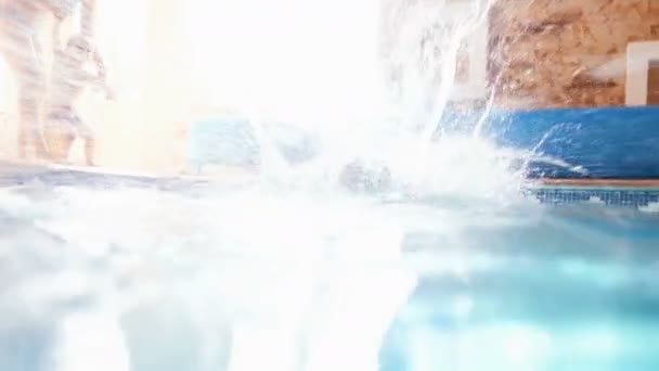 4k-Video von glücklicher Familie, die Spaß hat und im Schwimmbad im Haus springt — Stockvideo