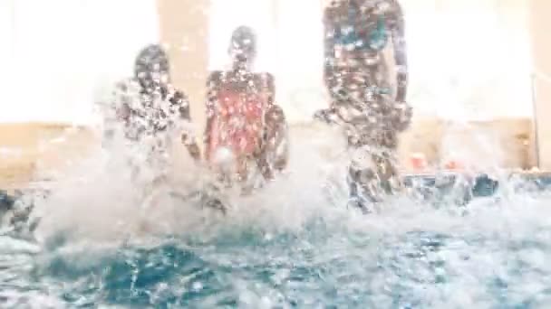 4k кадров счастливой семьи, сидящей у бассейна и двигающей ногами — стоковое видео
