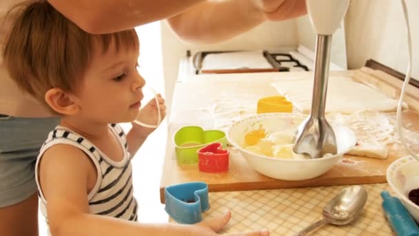 4 k beelden van jonge moeder haar peuter zoon koken en het gebruik van elektrische mixer op keuken onderwijs — Stockvideo