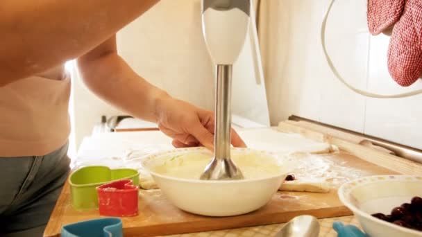 4 k närbild video av ung kvinna under omrörning och blanda ingredienser för degen i skålen på kök — Stockvideo