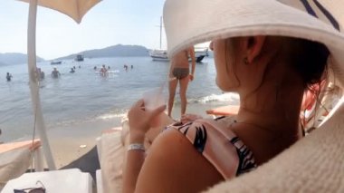 Closeup zarif genç kadın 4k video deniz plajda kokteyl ile rahatlatıcı