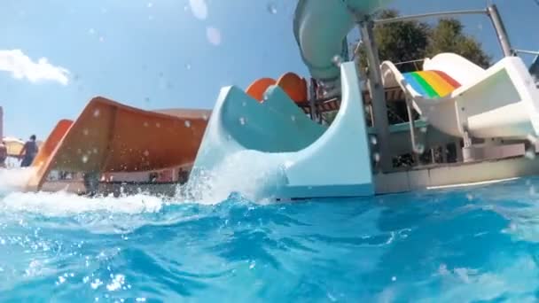 Filmato al rallentatore di tre acquascivoli colorati in aquapark nella luminosa giornata di sole — Video Stock