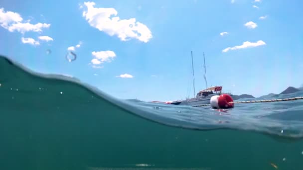 Slow motion undervattens bilder från förtöjda båtar och liv bojar i havet — Stockvideo