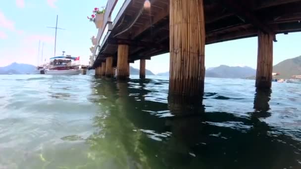 Langsames Mtoion-Filmmaterial von ruhiger See und alten Holzstegen an der Küste — Stockvideo
