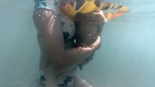 Zpomalené podvodní video mladé matky objímá svého syna batole v moři — Stock video