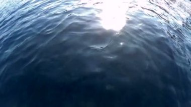 Yukarıda sakin deniz yüzeyi yansıtan güneş üzerinde göster