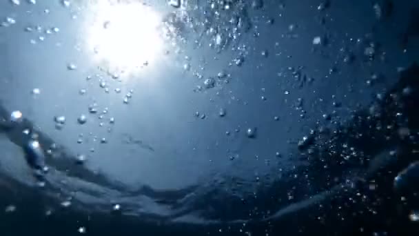 Slow motion underwater video from the sea bottom on floating air bubbles in sun light rays — Stock Video