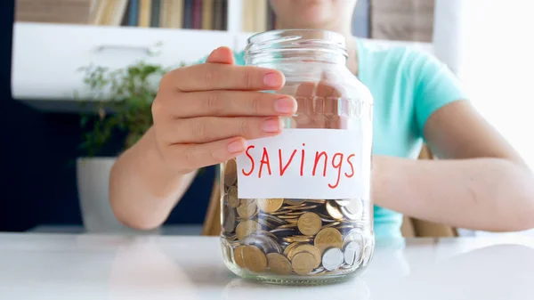 CLoseup image de femme avec ses économies d'argent dans un bocal en verre — Photo