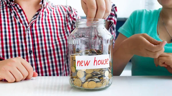 Imagem de close-up de jovens família economizando dinheiro para a compra de nova casa — Fotografia de Stock