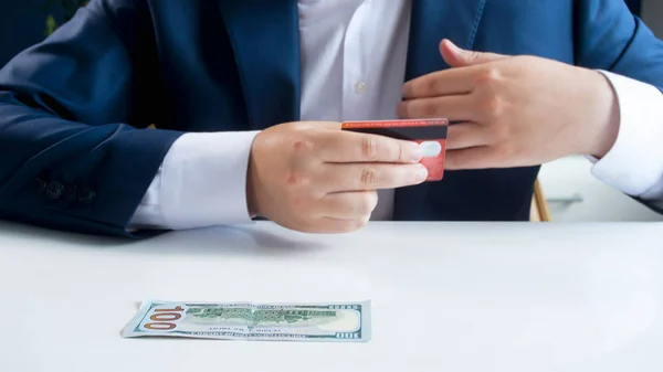 Closeup image of businesman chooding using credit card instead of paper money banknotes — Stock Photo, Image