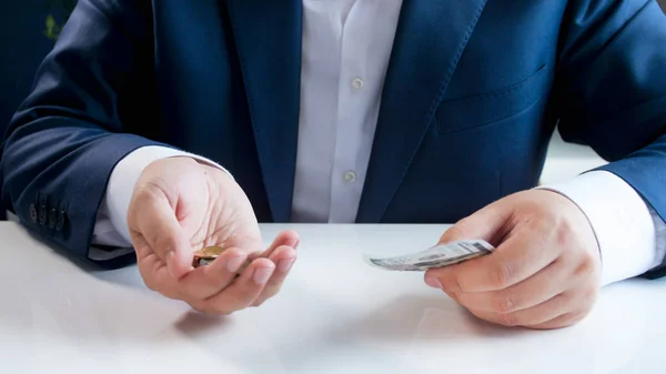 Imagem de perto do empresário segurando moedas em uma mão e cartão de crédito em outra — Fotografia de Stock