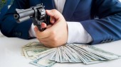 Közelkép kép üzletember ruha védi a pénzét, és amelynek célja a pisztolyt