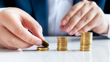 Kavramsal görüntü finansal ve banka istikrar, paraları yüksek yığınlarda koyarak işadamı