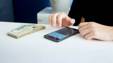 Portre fotoğraf kadın muhasebeci para büyük miktarda smartphone hesap makinesi üzerinde sayma