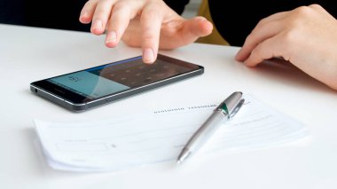 İşkadını kişisel bankacılık çek ödemeleri hesaplamak için hesap makinesini kullanarak closeup görüntü