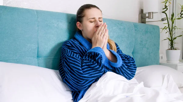 Retrato de mujer enferma tiene gripe acostada en la cama y tos —  Fotos de Stock