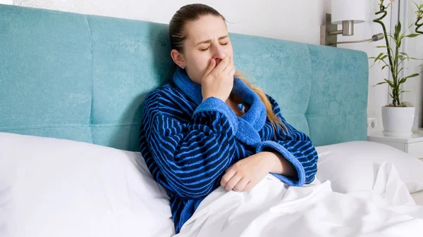 Portrait of young sick woman coughing and measuring temperature — Stock Photo, Image