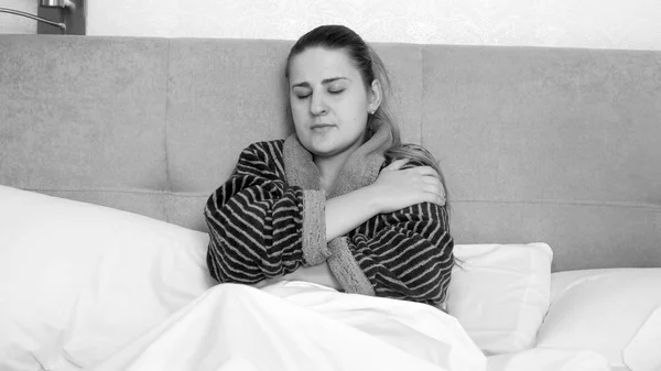 ベッドで毛布の下で横になっているバスローブを着て病気の若い女性の黒と白の肖像画 — ストック写真