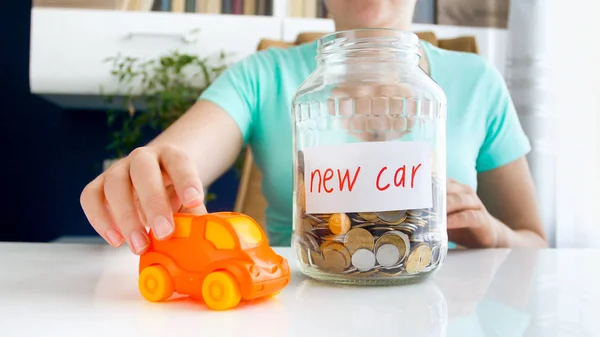 Closeup image of young woman dreaming of buying new car and saving money for purchasing automobile — Stock Photo, Image