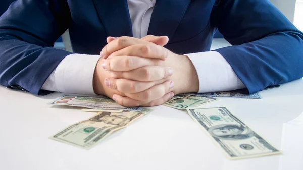 Imagem de close-up do empresário rico bem sucedido sentado atrás da mesa coberto com dinheiro — Fotografia de Stock