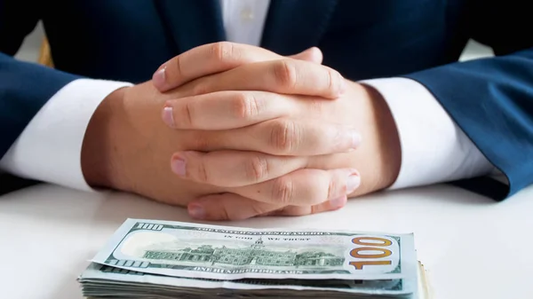 Closeup image of businessman sitting behind office desk with big stack of money — Stock Photo, Image