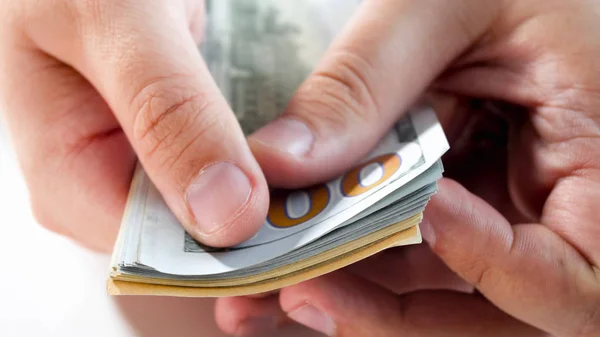 Closeup image of man counting big stack of US dollars in hands — Stock Photo, Image