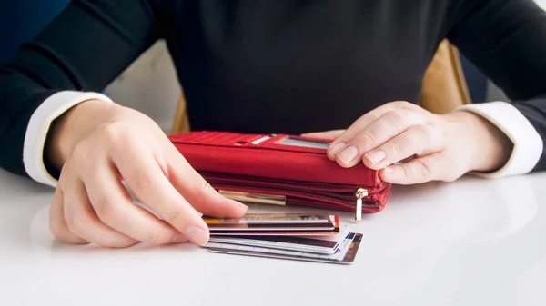 Крупный план фото молодой женщины положить кредитки в кожаный кошелек — стоковое фото