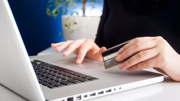 Closeup photo of young woman doing onkine shopping and holding credit card — Stock Photo, Image