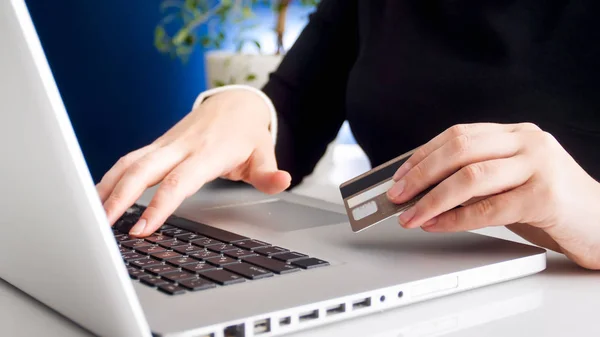 Closeup photo of young woman using laptop and holding credit card — Stock Photo, Image