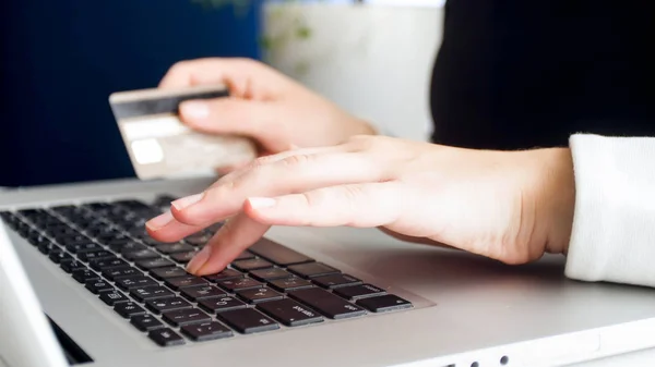 Closeup photo of woman typing on computer keyboard and holding credit card — Stock Photo, Image