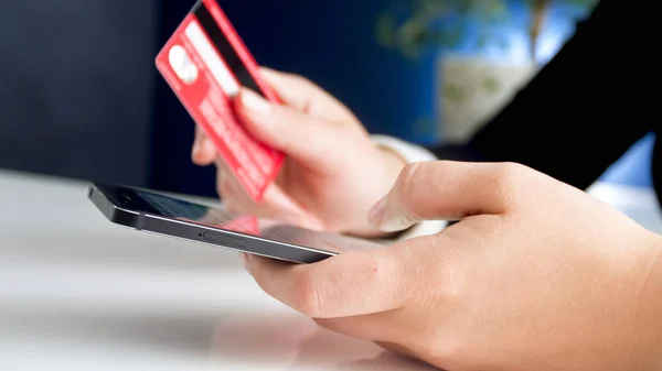 Closeup photo of young woman holding smartphone and credit card — Stock Photo, Image