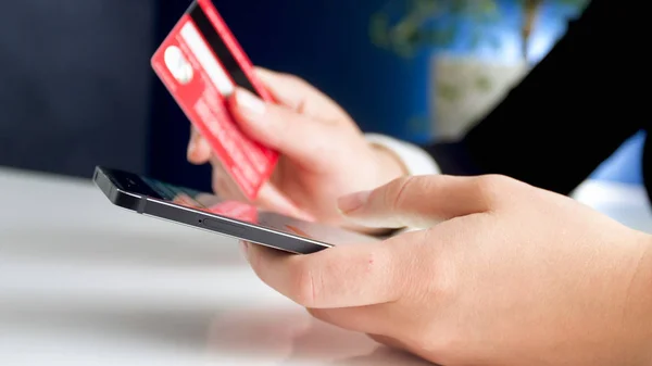 Closeup image of young woman making online purchases with credit card and smartphone — Stock Photo, Image