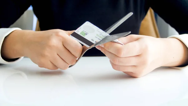 Closeup image of young woman cutting credit card with scissors — Stock Photo, Image