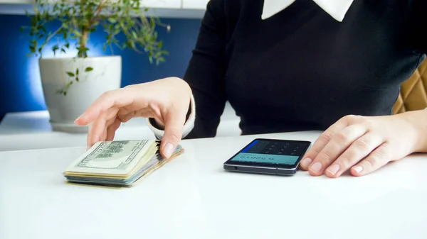 Közelkép kép üzletasszony számít pénz a smartphone kalkulátor — Stock Fotó