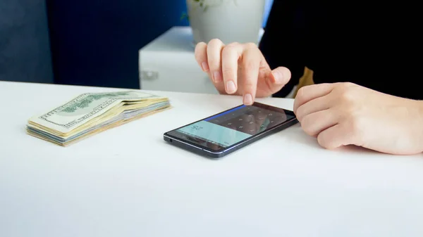 Closeup image of busineswoman making financial calculations on smartphone — Stock Photo, Image