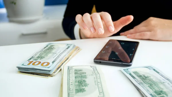 Közelkép kép női bank munkavállaló számológéppel smartphone közben számolja a pénzt — Stock Fotó