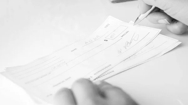 Imagen en blanco y negro de la mujer escribiendo cheque bancario de pago —  Fotos de Stock