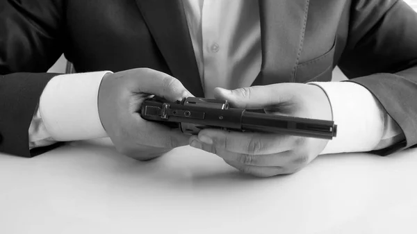 Black and white image of businessman holding revolver in hands — Stock Photo, Image
