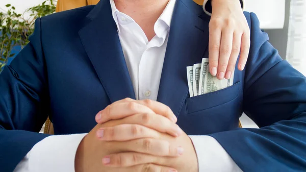 Nahaufnahme Foto einer weiblichen Hand, die Geld aus der Tasche eines Geschäftsmannes stiehlt — Stockfoto